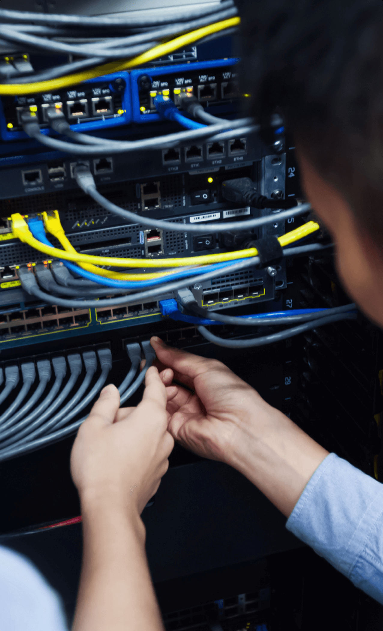 Young IT engineer inspecting network cable