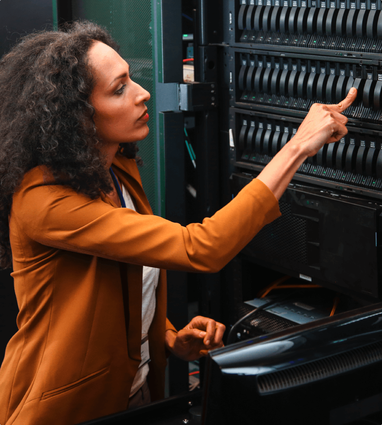 Woman taking out hard drive from a rack of disks in a data center. Cloud computing technician.