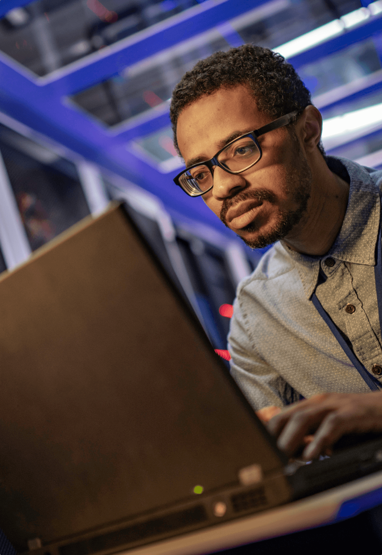 Low angle view of an IT technician using a laptop computer for server maintenance in a data center.