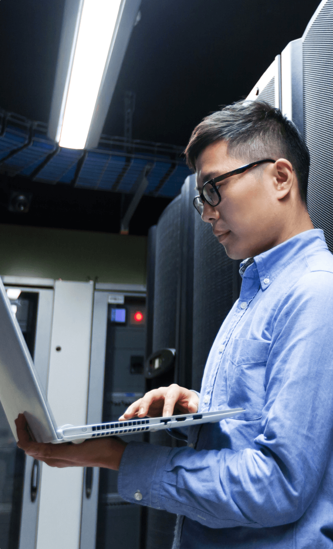 Young IT engineer inspecting data center servers.